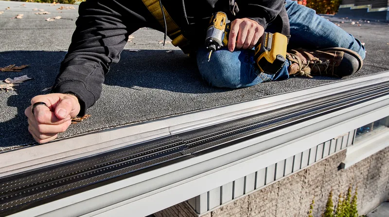 Installer adjusting a downspout elbow during a gutter repair